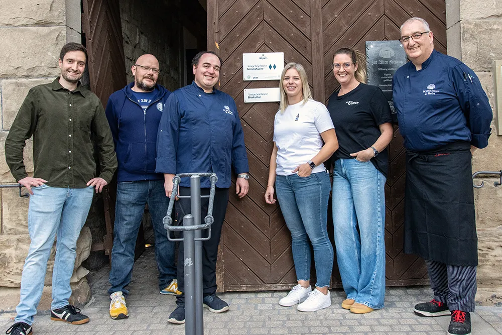 Gruppe vor Schild am Restaurant